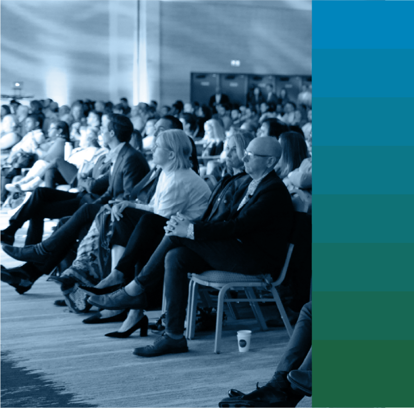 Audience listening to speaker on stage with blue gradient on right side